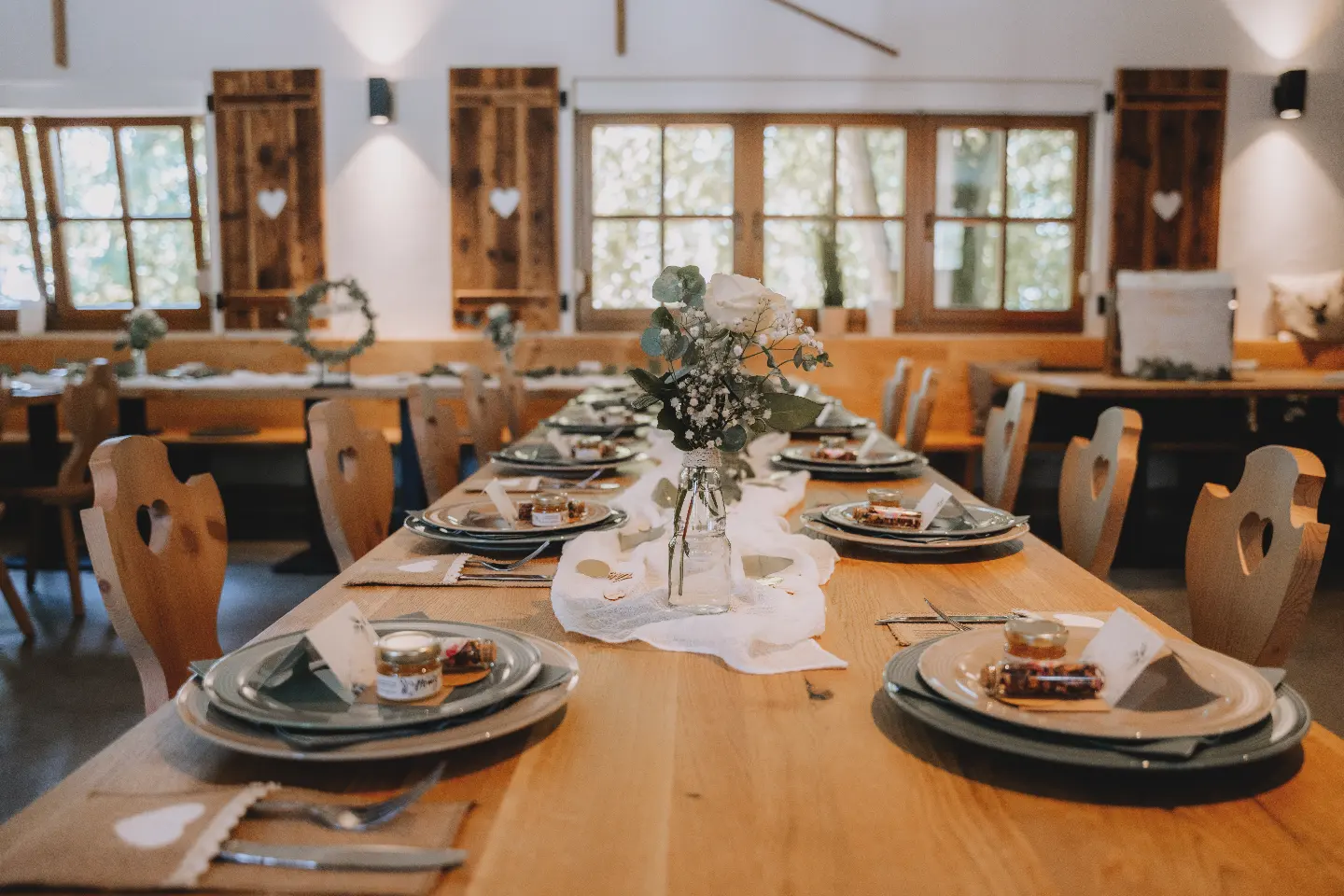 Elegant in Weiß und Eukalyptus gedeckte Hochzeitstafel in der Alm